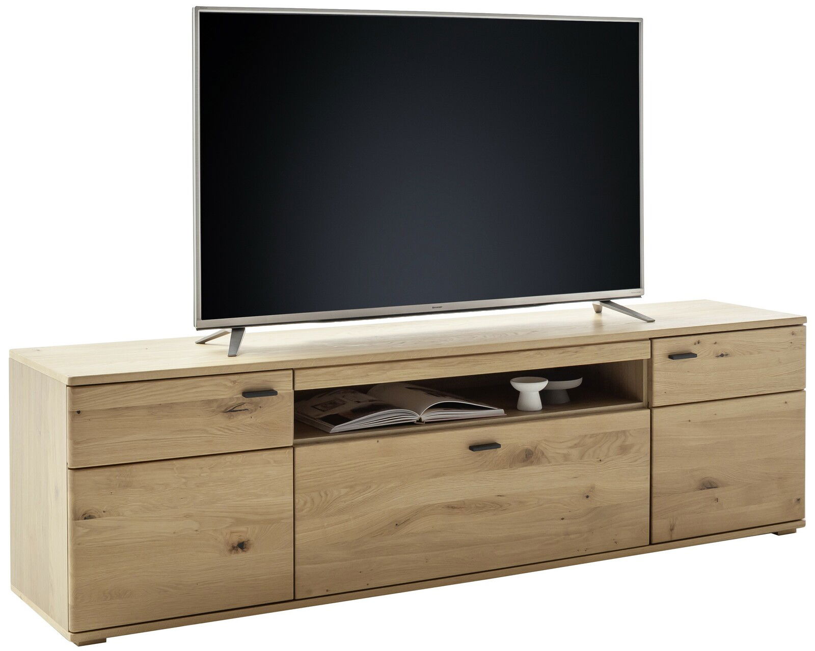 TV-Lowboard aus hellem Holz mit Schubladen und offenen Fächern, frontal betrachtet, mit einem großen Fernseher darauf.