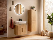 Modernes Badezimmer mit wandhängendem Waschtischunterschrank und hohem Holz-Hängeschrank, weißem Aufsatzwaschbecken, rundem beleuchtetem Spiegel und warmem Tageslicht am Fenster, frontale Perspektive