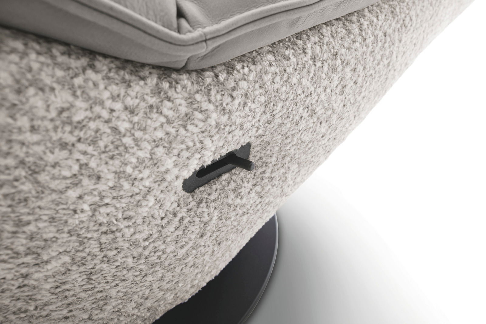 Nahaufnahme einer Schaukelliege mit weicher, strukturierter Polsterung und einem Hebel an der Seite, von der Seite betrachtet.