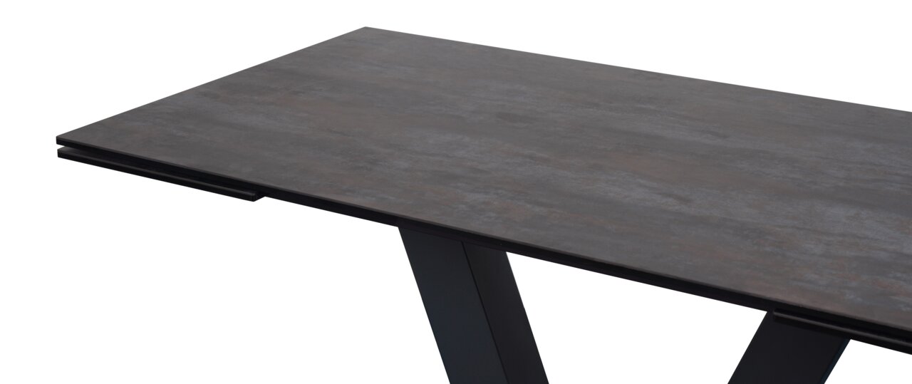 Moderner Esstisch mit dunkler Tischplatte und schrägen Beinen, seitliche Perspektive