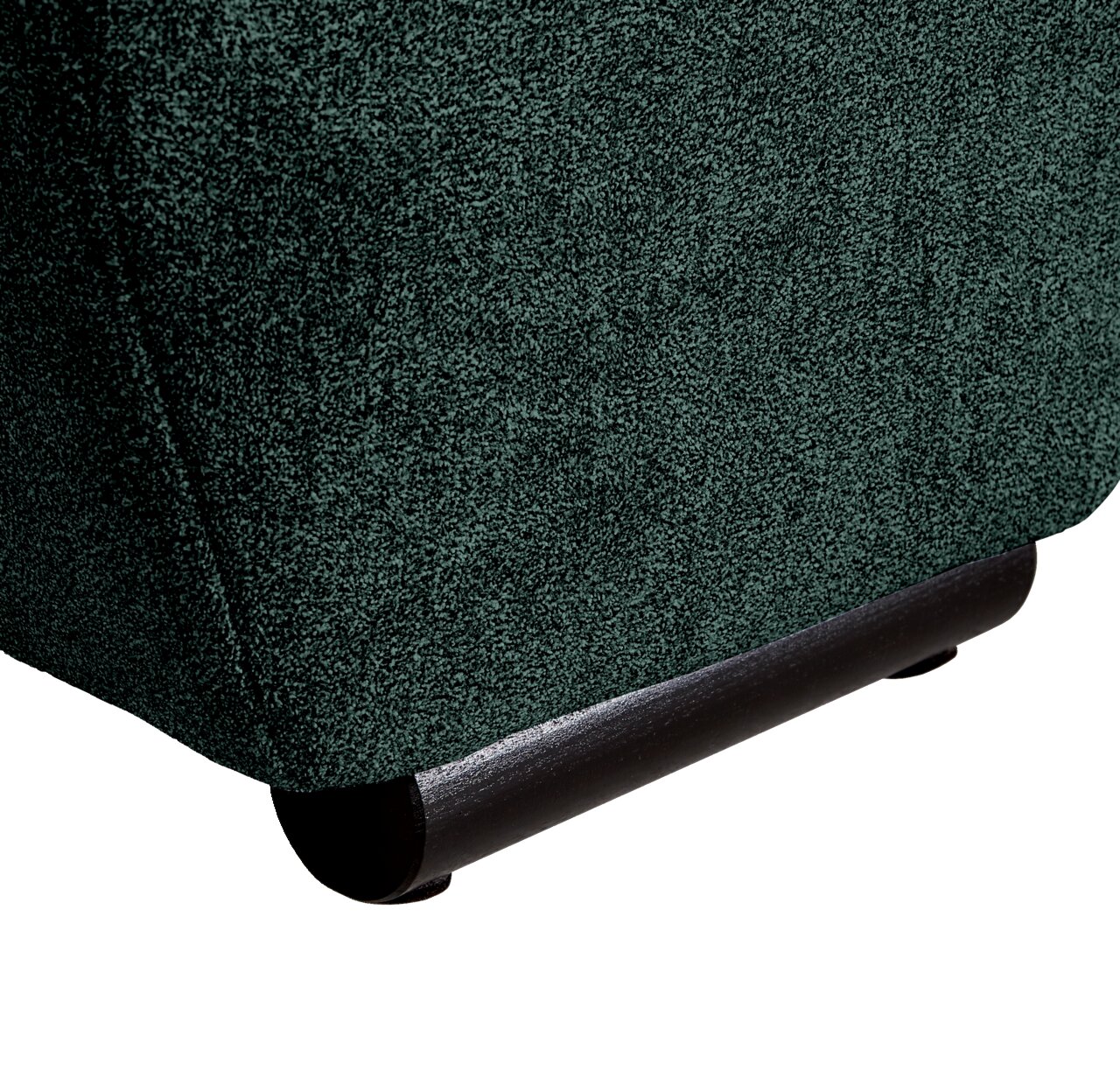 Close-up van de onderste hoek van een grote bank met donkergroene stoffen bekleding en zwarte poten, gezien vanaf de zijkant