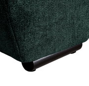 Close-up van de onderste hoek van een grote bank met donkergroene stoffen bekleding en zwarte poten, gezien vanaf de zijkant