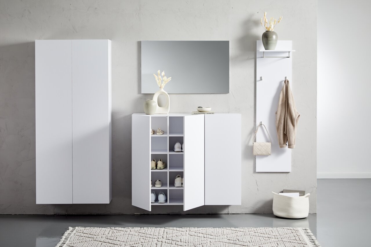 Moderne witte hangmeubels in een minimalistische ruimte, gezien vanaf de voorkant. Links een hoge kast, in het midden een dressoir met open deuren en rechts een kapstok met haken en een legplank.