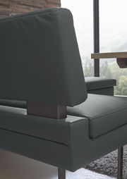 Nahaufnahme einer modernen Eckbank mit dunkelgrauem Lederbezug und Metallgestell, seitliche Perspektive.