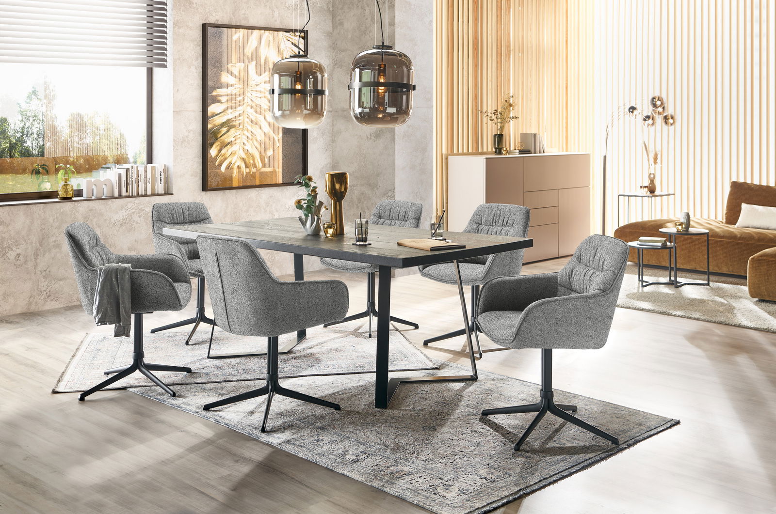 Moderner Essbereich mit grauen Armlehnstühlen und einem dunklen Esstisch, seitliche Perspektive.