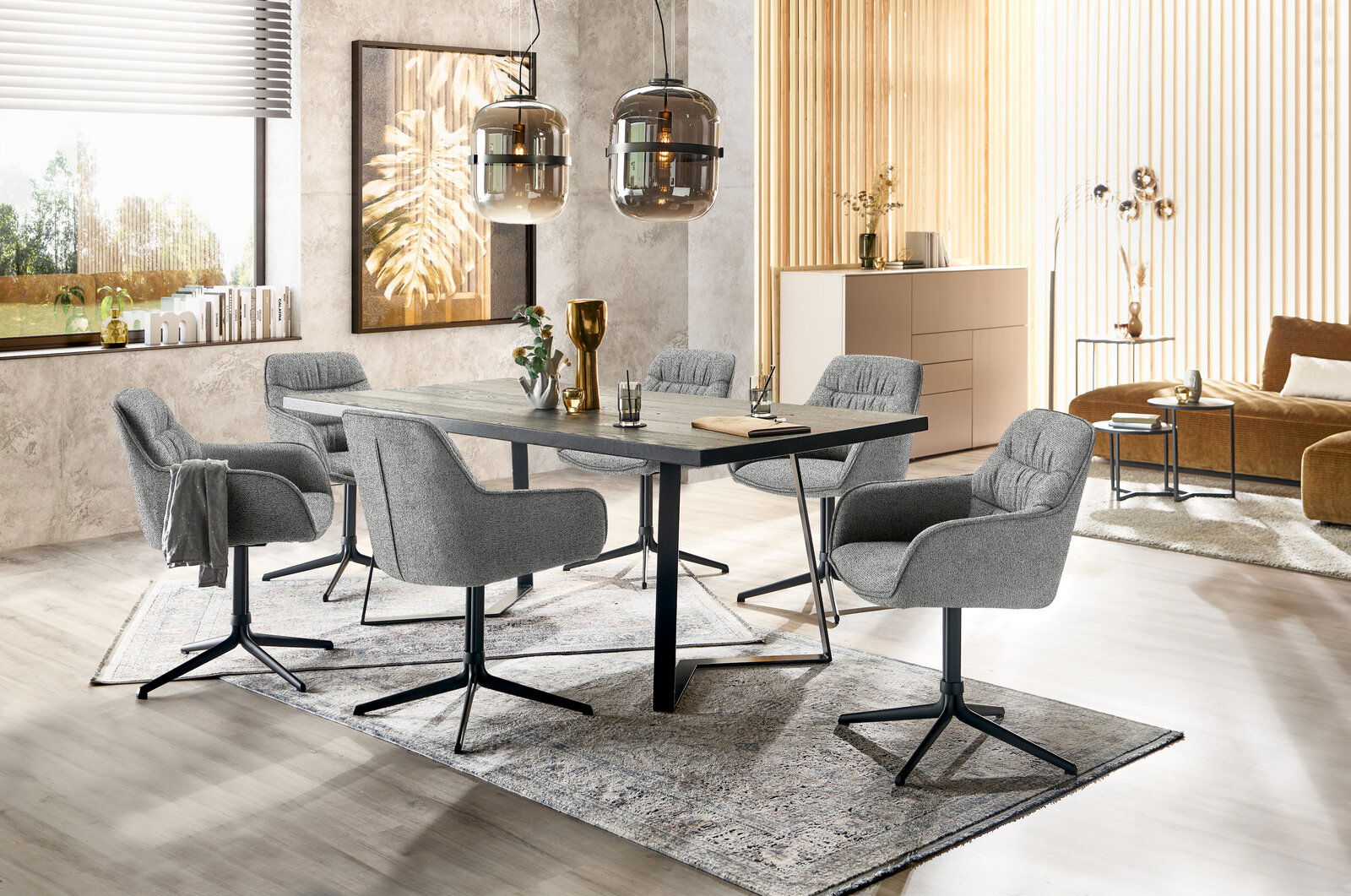 Moderner Essbereich mit grauen Armlehnstühlen und einem dunklen Esstisch, seitliche Perspektive.