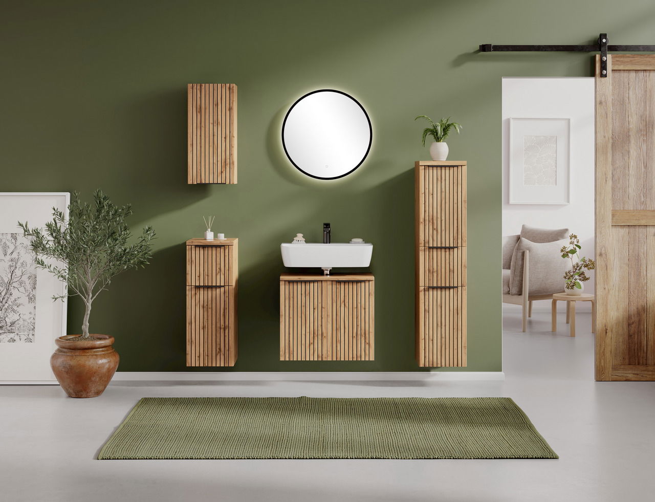 Runder Spiegel an einer grünen Wand in einem stilvoll eingerichteten Badezimmer mit Holzschränken und Pflanzen, Frontalansicht.
