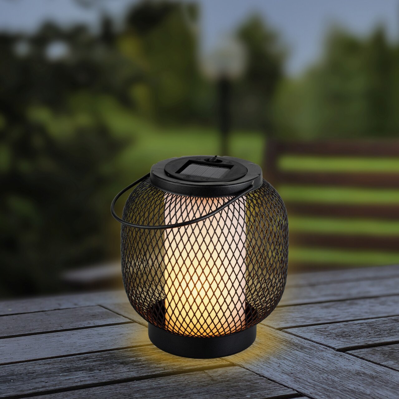 Lumineo Solar Laterne BELEUCHTUNG26 Solarlaterne aus Metall mit Netzdesign, leuchtend auf einem Holztisch, seitliche Perspektive