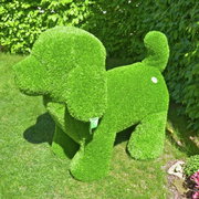 Grüne Hundeskulptur aus Kunstrasen, stehend im Garten, seitliche Perspektive