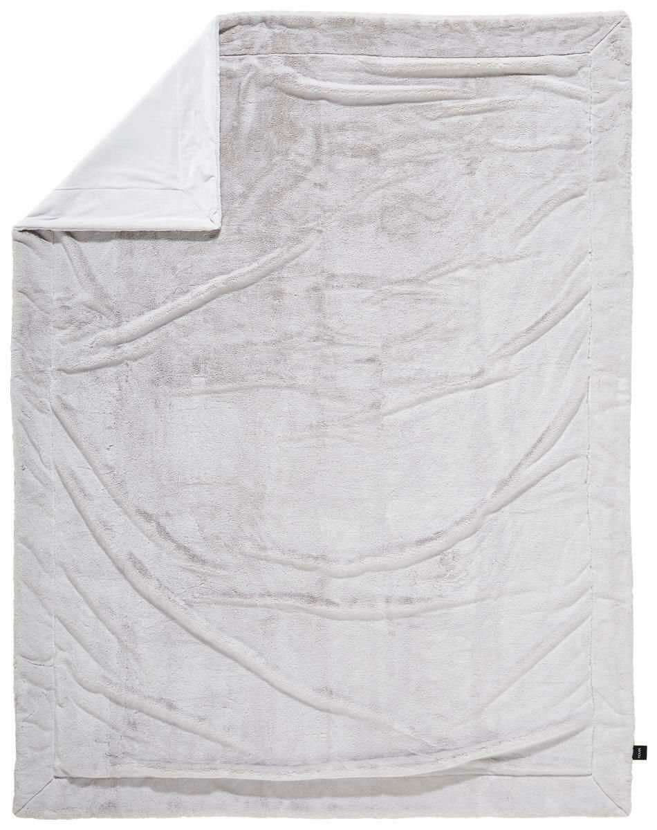 Obenansicht einer großen, weichen Felldecke in hellem Grau mit umgeschlagener Ecke.