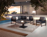 Moderne Loungegarnitur in stilvoller Außenumgebung mit Blick auf den Sonnenuntergang, bestehend aus einem Sofa, einem Sessel und einem Tisch auf einer Terrasse.