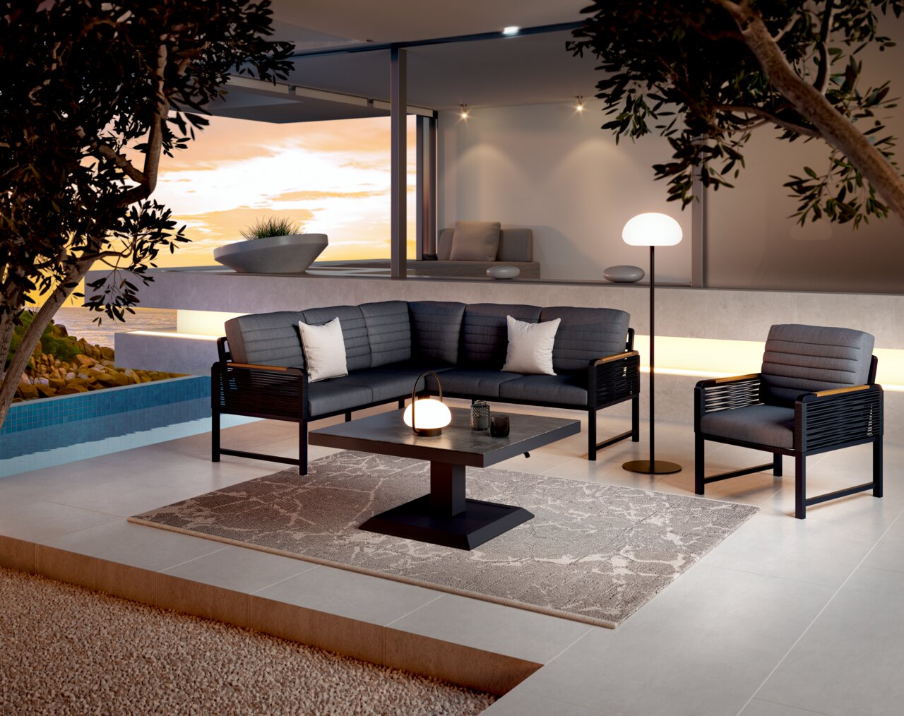 Moderne Loungegarnitur in stilvoller Außenumgebung mit Blick auf den Sonnenuntergang, bestehend aus einem Sofa, einem Sessel und einem Tisch auf einer Terrasse.