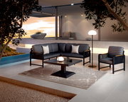 Moderne Loungegarnitur in stilvoller Außenumgebung mit Blick auf den Sonnenuntergang, bestehend aus einem Sofa, einem Sessel und einem Tisch auf einer Terrasse.