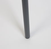 Nahaufnahme eines Tischbeins eines Beistelltisches in dunkler Farbe, von der Seite betrachtet.