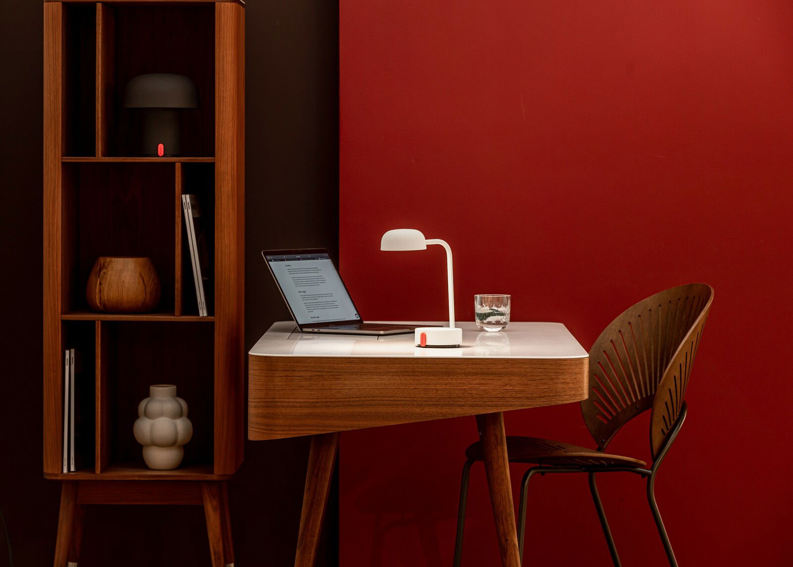 Moderner Schreibtisch mit weißer Tischlampe und Laptop, seitliche Perspektive