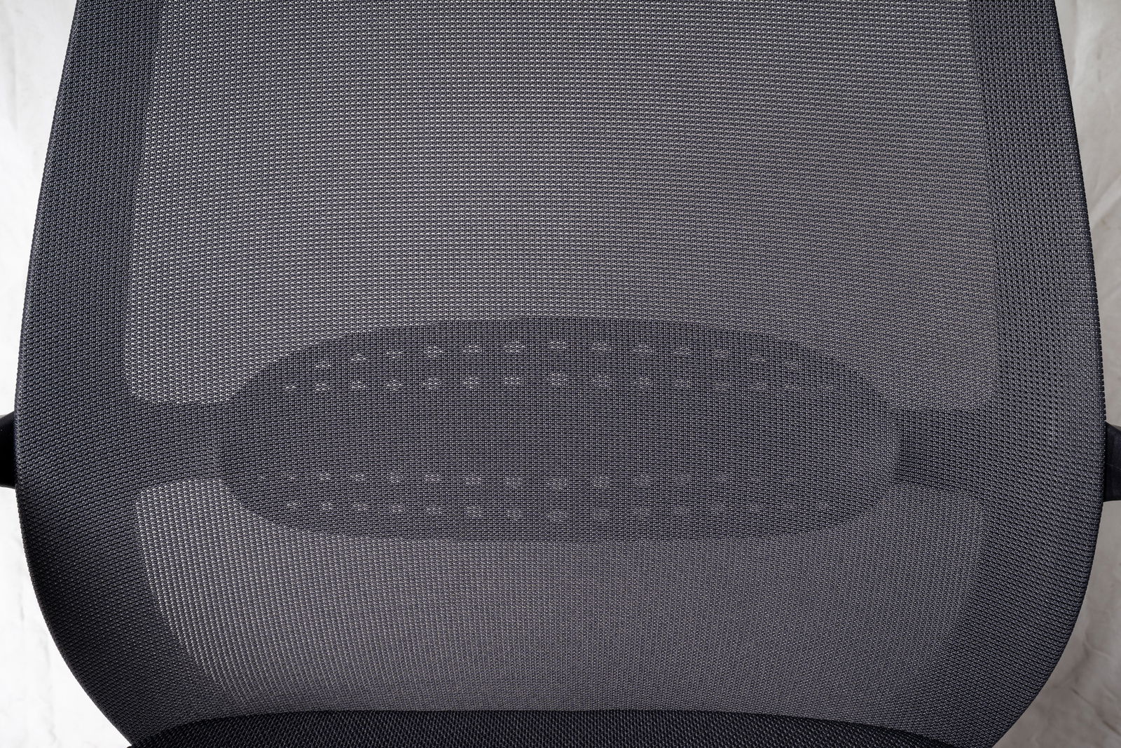 Rückansicht eines Drehstuhls mit Netzrückenlehne, von oben betrachtet.