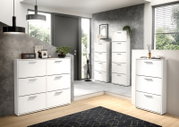 Moderne witte schoenenrek met meerdere vakken, in een stijlvolle, lichte ruimte met een houten vloer en een grijze muur, gezien vanuit het perspectief linksvoor.