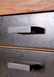 Nahaufnahme von zwei Schubladengriffen an einem Servierwagen aus Metall mit Holzdetails, seitliche Perspektive.