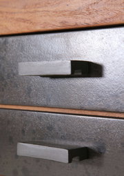 Nahaufnahme von zwei Schubladengriffen an einem Servierwagen aus Metall mit Holzdetails, seitliche Perspektive.