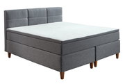 Graues Boxspringbett mit gepolstertem Kopfteil, seitliche Perspektive