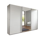 Moderner, dreitüriger Schwebetürenschrank in Weiß mit Spiegel in einem hellen Raum, seitliche Perspektive.