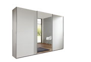 Moderner, dreitüriger Schwebetürenschrank in Weiß mit Spiegel in einem hellen Raum, seitliche Perspektive.