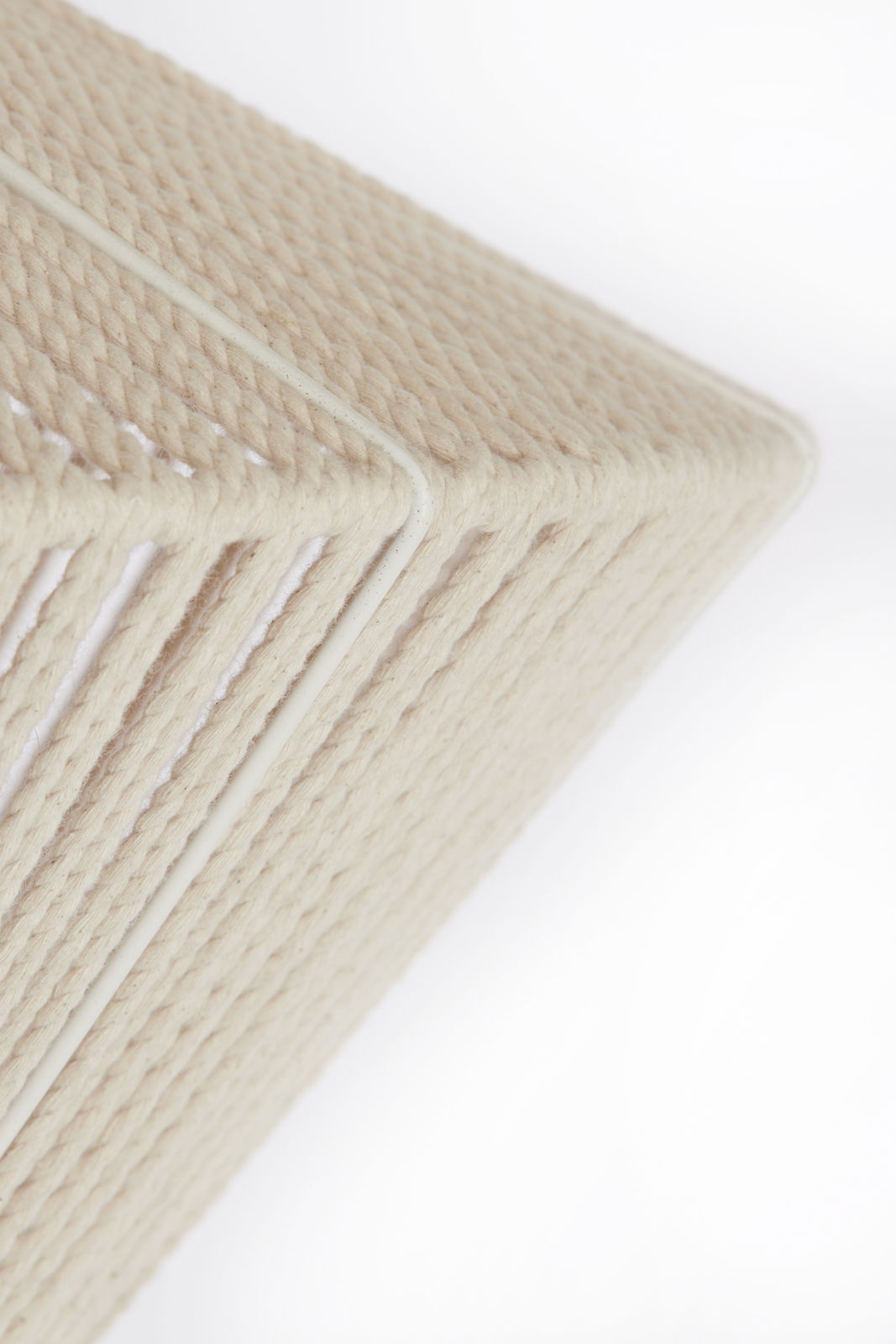 Nahaufnahme einer Hängeleuchte mit einem cremefarbenen, geflochtenen Seildesign, seitliche Perspektive.