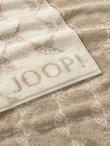 Beiges Handtuch mit eingewebtem Muster und dem Schriftzug 'JOOP!' in Nahaufnahme.