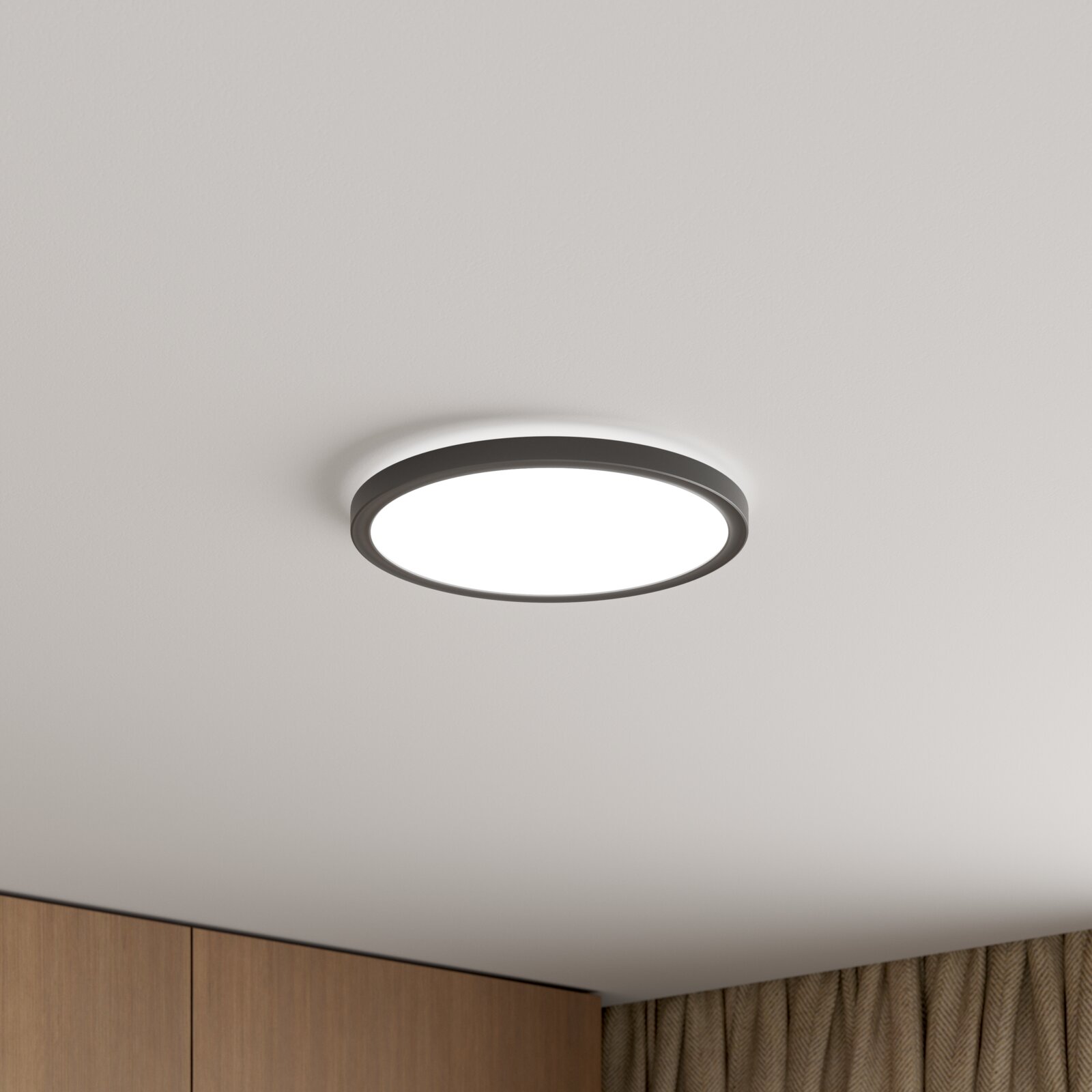Novel LED-Deckenleuchte MACON Runde, flache LED-Deckenleuchte mit dunklem Rahmen und diffuser Lichtfläche, an weißer Decke montiert, in leichter Untersicht von unten fotografiert