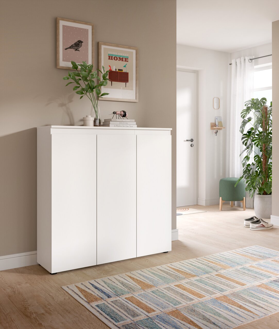 MID.YOU Universalschrank SCARPA Weißes Sideboard mit drei Türen im Flur, dekoriert mit Vase und Bildern an der Wand, fotografiert in frontaler Perspektive leicht von links.