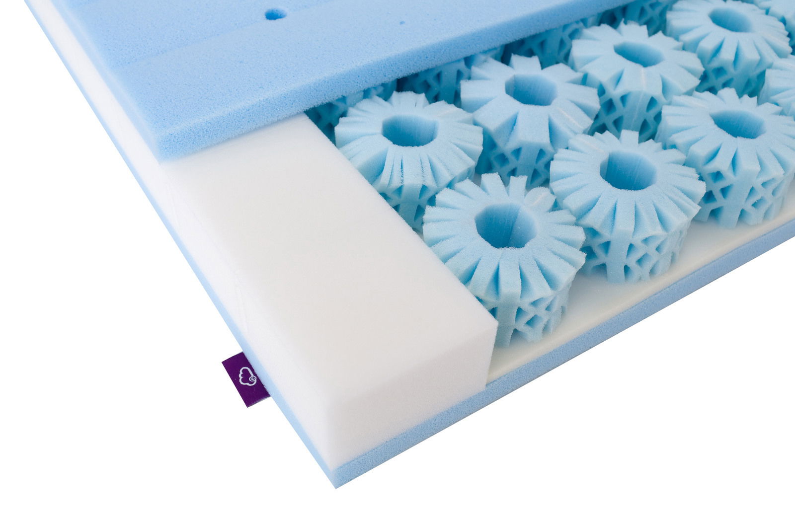 Nahaufnahme einer Matratze mit blauen Schaumstoffelementen und einem weißen Schaumstoffblock, perspektivisch von der Seite aufgenommen.