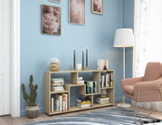 Modernes Bücherregal/Sideboard in heller Eichenholz-Optik mit offenen, asymmetrischen Fächern, dekoriert mit Büchern, Kerzenständern und Pflanzen im Wohnzimmer; perspektivisch in leichter Frontansicht von schräg rechts.