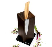 Magnet-Messerblock aus Esche mit einem Messer, umgeben von geschnittenen Frühlingszwiebeln, aus der Vogelperspektive.