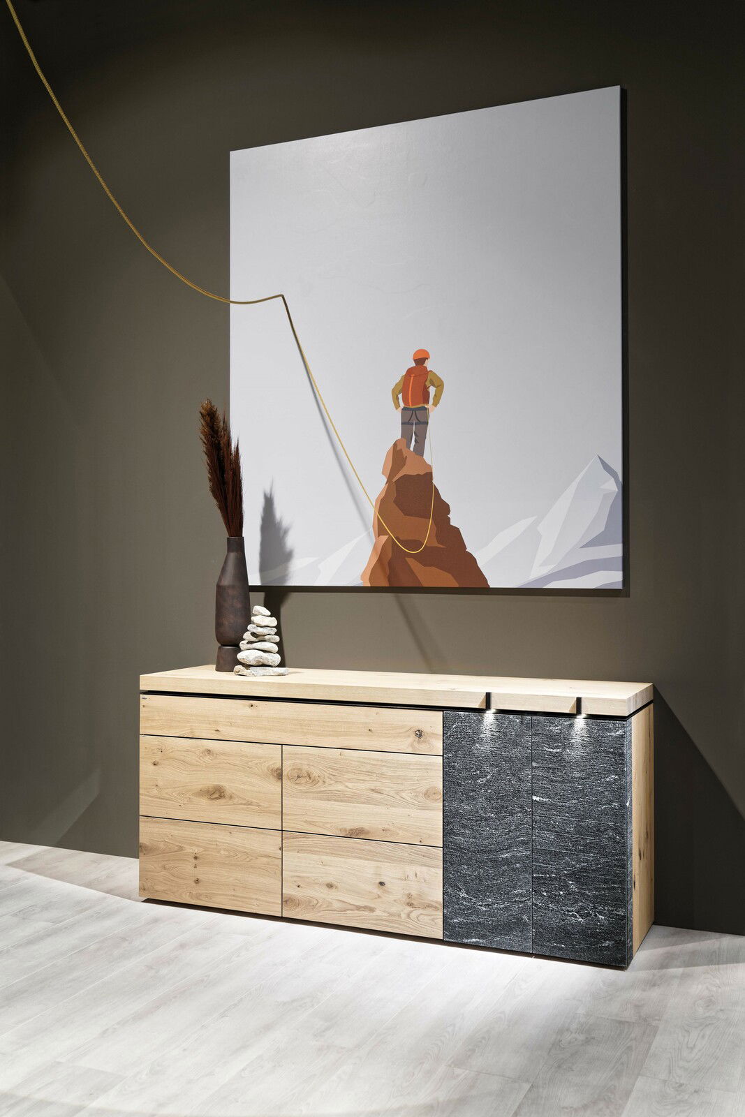 Voglauer Sideboard V-ROCK aus Holz und Stein, frontal fotografiert, mit dekorativer Vase und Kunstwerk im Hintergrund.