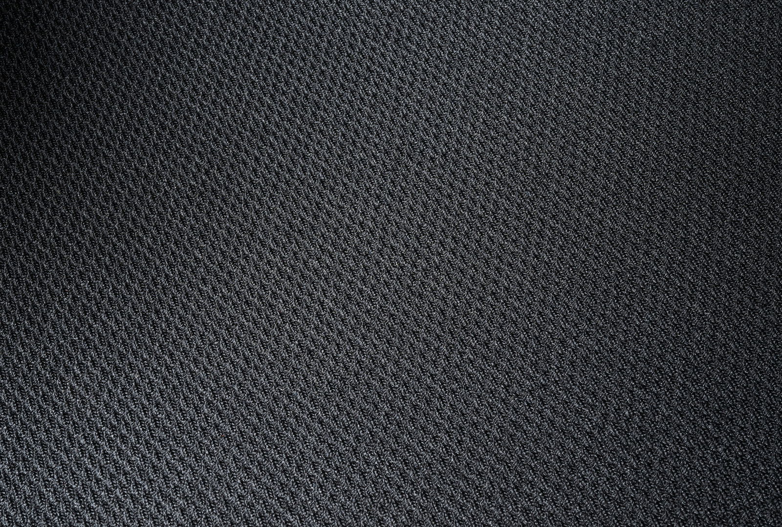 Nahaufnahme eines schwarzen Stoffbezugs mit feiner Textur, Draufsicht