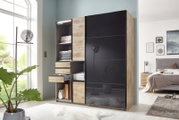 Moderner Schwebetürenschrank mit zwei Türen, links offen mit Regalen und Schubladen, rechts mit schwarzer Front. Perspektive: Frontalansicht im Schlafzimmer.