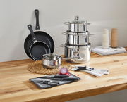 Kochtopf-Starter-Set 10-tlg. aus Edelstahl und Antihaft-Pfannen, seitliche Perspektive auf einem Holztisch arrangiert.