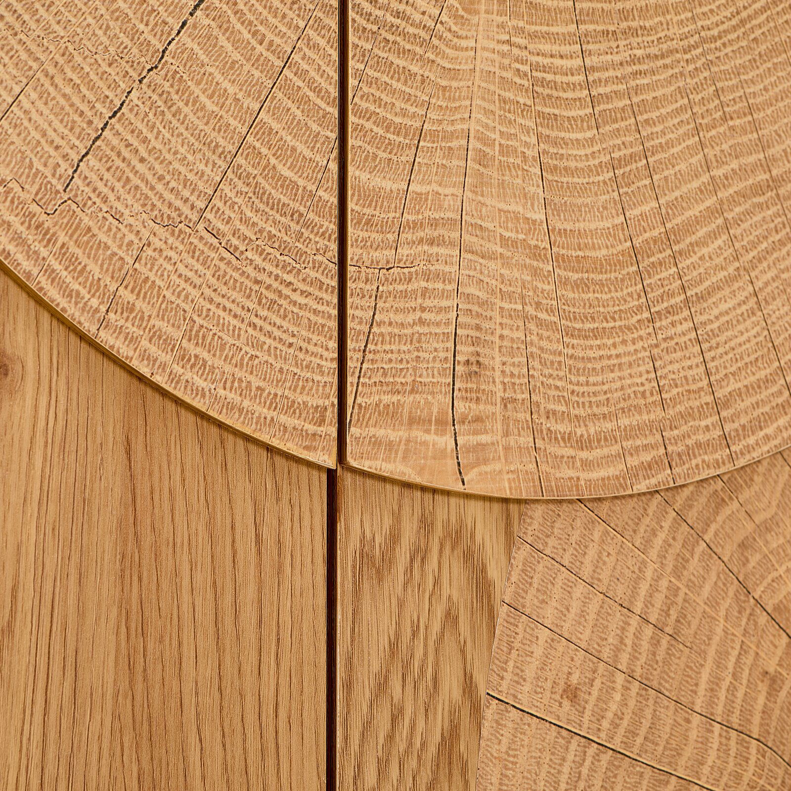 Detailaufnahme in Draufsicht: helle Holzoberfläche mit sichtbaren Jahresringen und Maserung, segmentartig zusammengesetzte Holzplatten mit feinen Rissen und Fugen