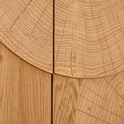 Detailaufnahme in Draufsicht: helle Holzoberfläche mit sichtbaren Jahresringen und Maserung, segmentartig zusammengesetzte Holzplatten mit feinen Rissen und Fugen