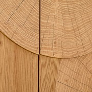 Detailaufnahme in Draufsicht: helle Holzoberfläche mit sichtbaren Jahresringen und Maserung, segmentartig zusammengesetzte Holzplatten mit feinen Rissen und Fugen