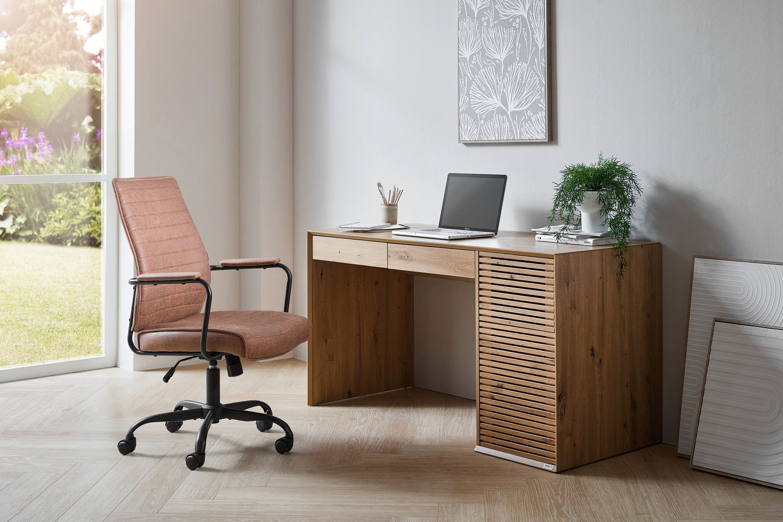 Moderner Schreibtisch aus Holz mit Laptop und Pflanzen, seitliche Perspektive.