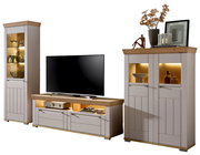Wandkombination bestehend aus einem hohen Schrank, einem TV-Board und einem zweitürigen Schrank, alle in hellem Holz mit Glaseinsätzen und Beleuchtung, frontal betrachtet.