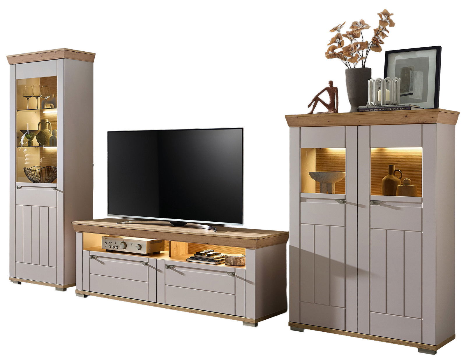 Wandkombination bestehend aus einem hohen Schrank, einem TV-Board und einem zweitürigen Schrank, alle in hellem Holz mit Glaseinsätzen und Beleuchtung, frontal betrachtet.