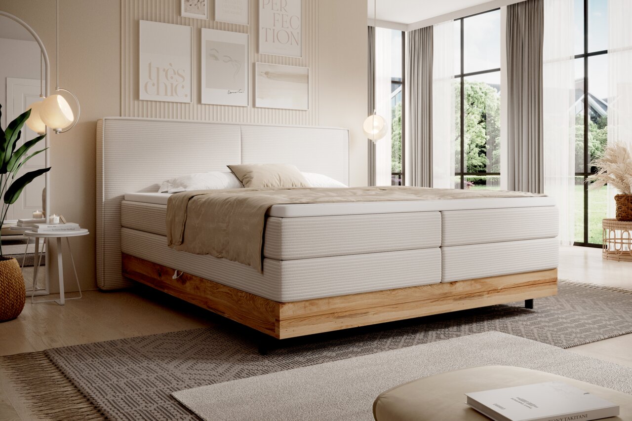 Modernes Boxspringbett in einem hellen, stilvollen Schlafzimmer mit großen Fenstern, seitliche Perspektive.