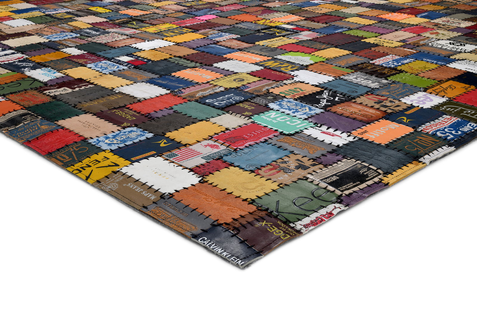 Bunter Lederteppich aus zusammengenähten Etiketten, perspektivisch von der Seite aufgenommen.