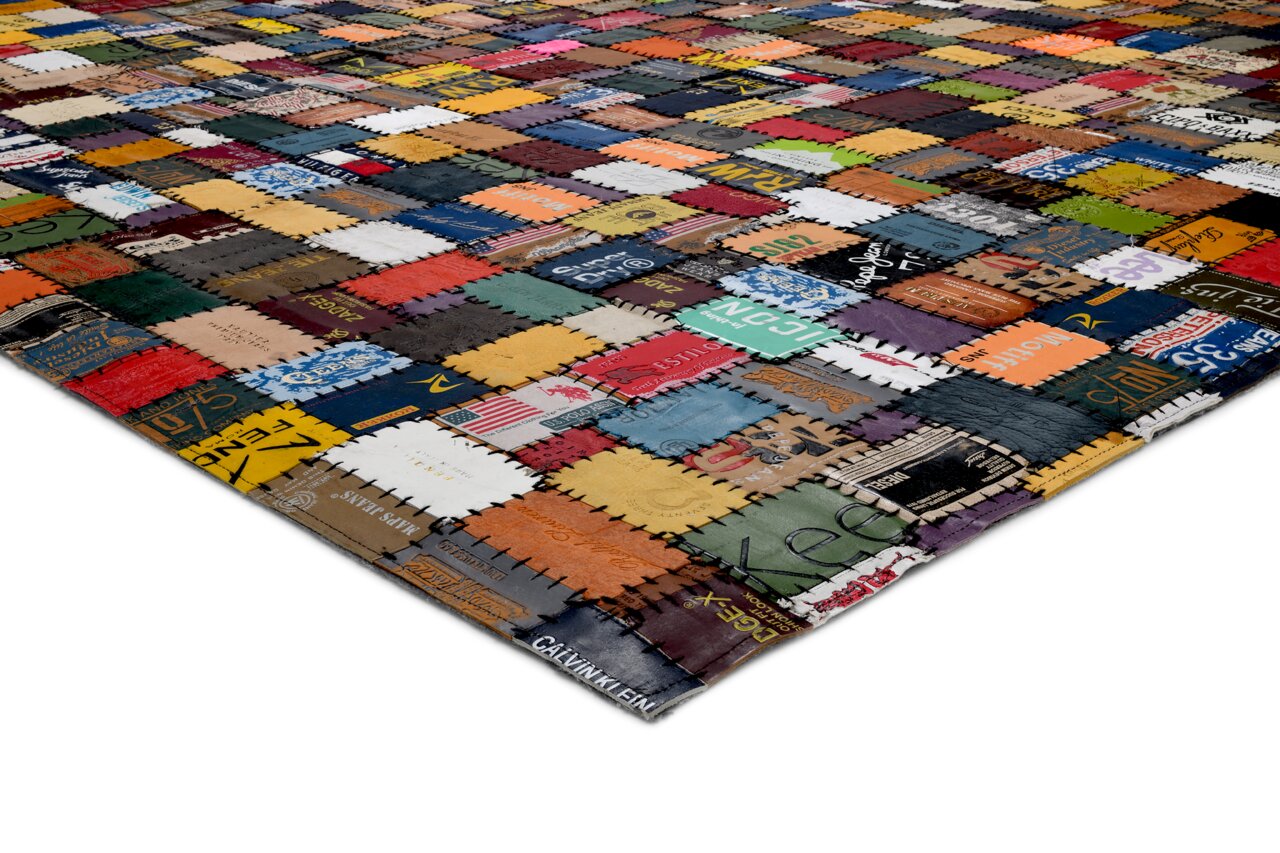 Bunter Lederteppich aus zusammengenähten Etiketten, perspektivisch von der Seite aufgenommen.