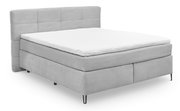 Graues Boxspringbett mit gestepptem Kopfteil, seitliche Perspektive