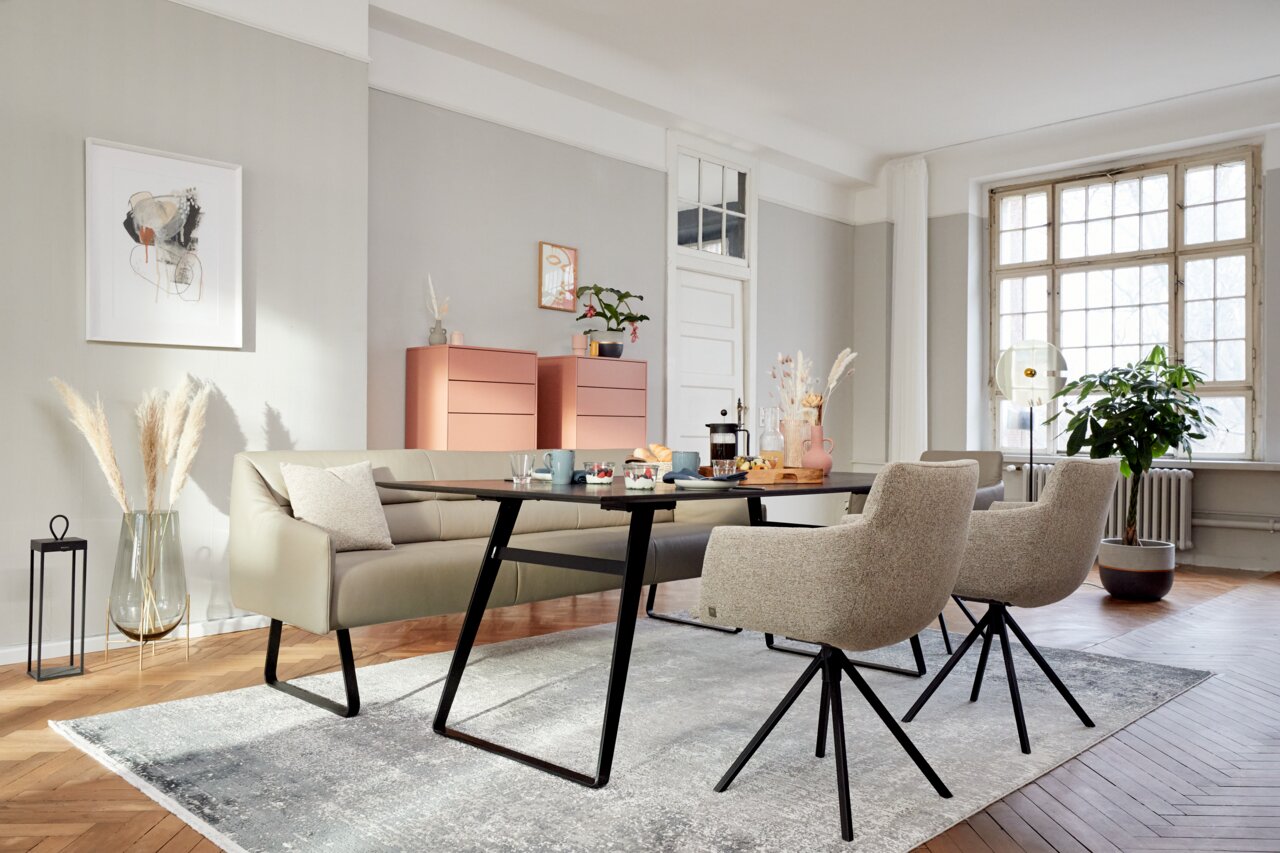 Moderne Esszimmer-Szene mit einem Tisch und Stühlen in einem hellen Raum, seitliche Perspektive.