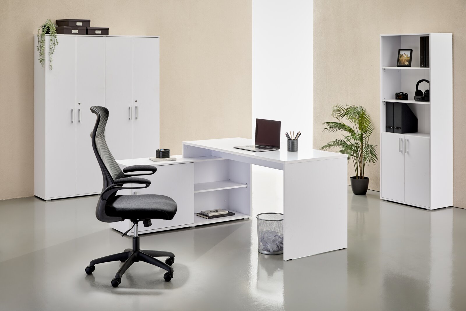 XORA Büro-Set ALEX Modernes weißes L-förmiges Büroschreibtisch-Set mit integriertem Sideboard und offenen Regalfächern, im Büro arrangiert; Perspektive: frontale leicht schräge Ansicht von links.