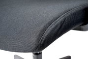 Nahaufnahme eines grauen Drehstuhlsitzes mit Textilbezug, seitliche Perspektive